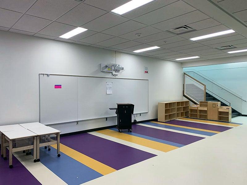 a common area is defined by a striped floor and 学习之墙 and teacher station