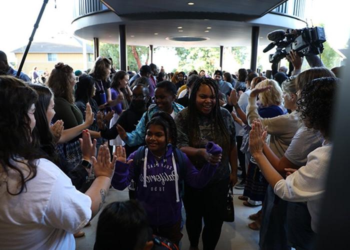 a crowd of people includes children and adults and are moving toward the camera